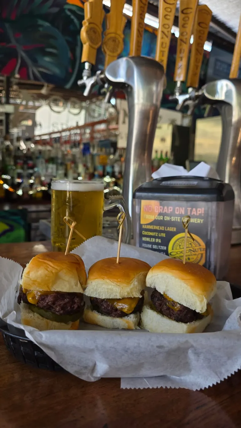 Deliciosas minihamburguesas servidas con papas fritas y cerveza artesanal