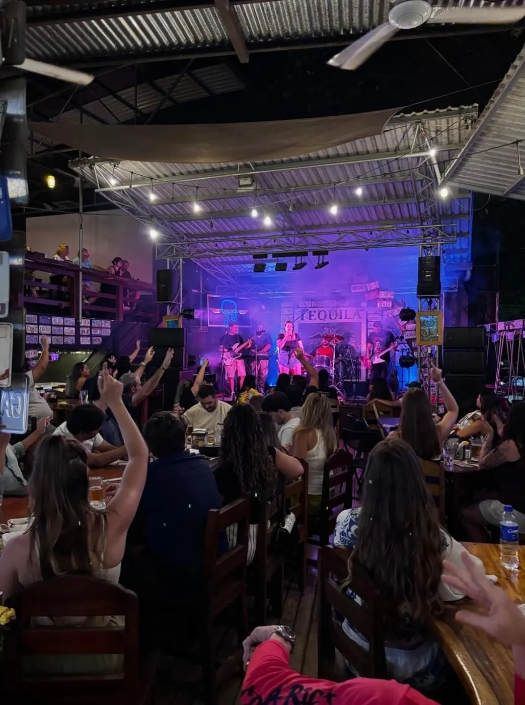 Una banda tocando en vivo frente al público en el Tequila Stage de Coconutz